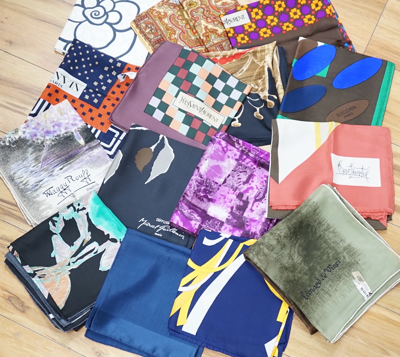 A collection of vintage silk scarves including Lanvin, Yves Saint Laurent, Maggy Rouff and one retailed by Harrods